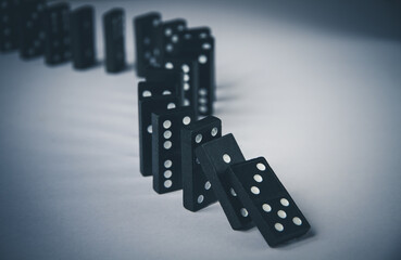 Black dominoes chain on table background