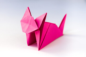 Pink paper cat origami isolated on a white background