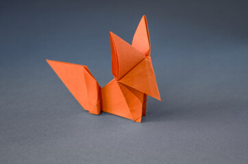 Orange paper fox origami isolated on a grey background
