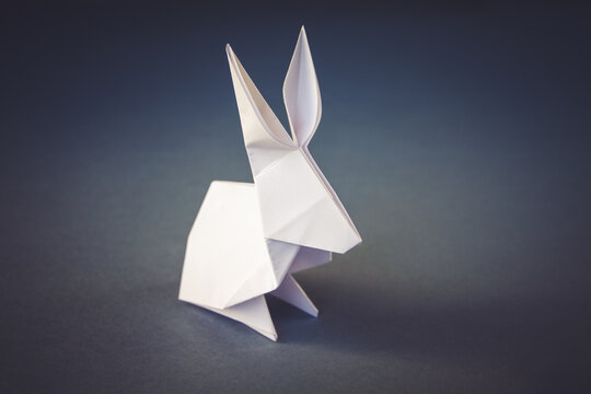 White paper rabbit origami isolated on a grey background