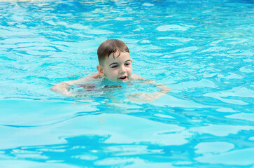 Fototapeta na wymiar a boy swims in the pool