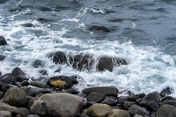 Waves comes rocky beach in cloudy day, Japan.