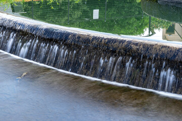 Water flow is divided by circular tank diversion in rural area in Japan.