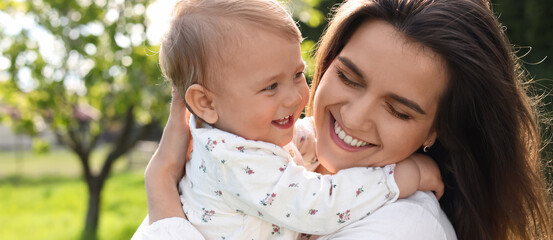 Fototapeta premium Happy mother with her cute baby in park on sunny day. Banner design