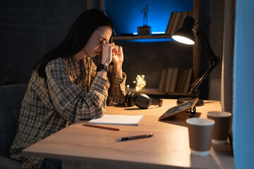 Fatigued asian woman student suffering eyestrain using tablet pc complaining at night at home. tired stressed young college girl massage nose bridge while painful.