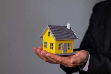 Fototapeta na wymiar Businessman Hand holding home model, mortgage loan concept