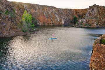 The guy on the sup board on the lake. Fitness recreational leisure activity. Beach rental equipment on travel vacation.