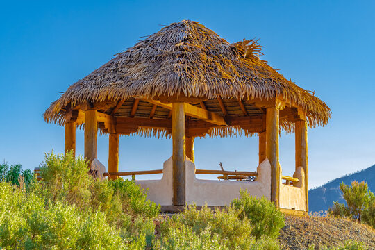 Wooden pergola at a beautiul morning light by the sea. Summer vacation, exotic pergola with palm leaves roof