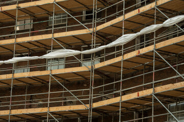 Modern home of office building construction with scaffolding. Cloudy sky background. New house development. Construction industry.