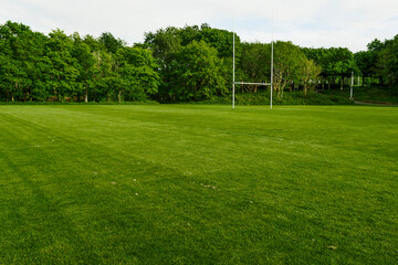Green field with tall goal post for Irish National sport hurling and camogie in a park. Popular activity in Ireland for man, woman and children. - obrazy, fototapety, plakaty