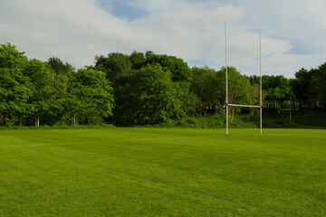 Green field with tall goal post for Irish National sport hurling and camogie in a park. Popular activity in Ireland for man, woman and children. - Powered by Adobe