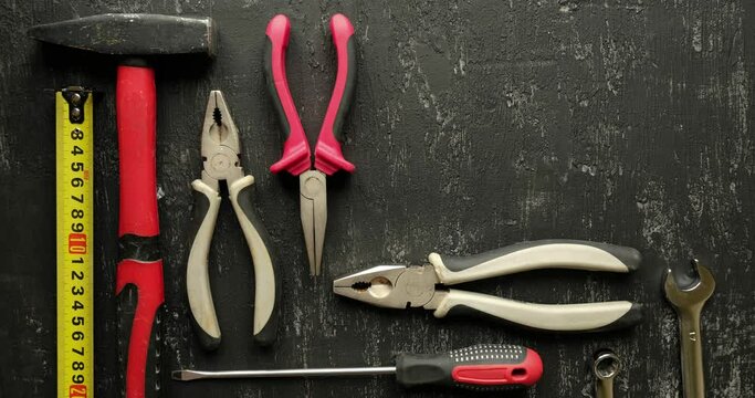 Collection of home repair tools on black background. Looped 4K stop motion animation