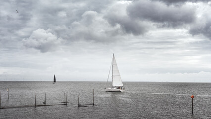 Sailboat on lake Ijsselmeer in cloudy weather, Enkhuzen, Netherlands. - 510759545