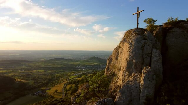 Aerial footage of sideways flight alongside cliff ledge with beautiful mountain panorama in the Swabian Alps in Southern Germany at sunset