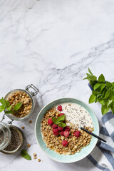 Breakfast, sweet dessert. Diet nutrition concept. Homemade granola with yogurt, chia seeds and raspberry on a marble tabletop. View from above. Copy space.