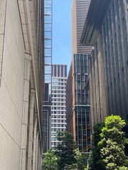 Obraz premium High-rise towers look from the ally at the central Tokyo Japan, Otemachi district, offices and restaurants, sunny weekday year 2022 June 13th