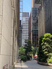 High-rise towers look from the ally at the central Tokyo Japan, Otemachi district, offices and restaurants, sunny weekday year 2022 June 13th