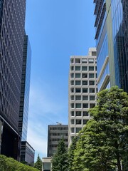 Obraz premium Modern office buildings at Tokyo Marunouchi corporate district, sunny weekday year 2022 June 13th, Japan