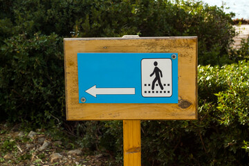 Warning arrow on the wooden sign indicating the walking path