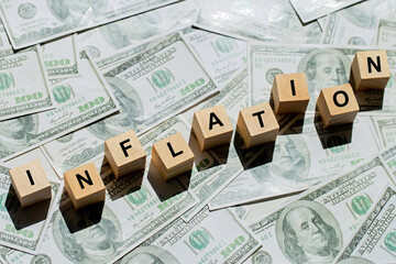 Wooden cubes with text inflation on US dollar money banknote. The idea for FED considers interest...