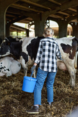 portrait of mature woman at cow farmer with bucket