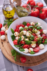 Caprese salad - Mini mozzarella cheese in glass bowl, tomato and basil