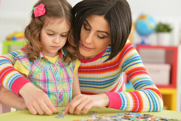 Portrait of mother playing with her cute little daughter