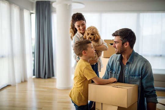 Happy young family unpacking cardboard boxes at new home