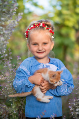 littie Ukrainian girl in vyshivanka with a kitten