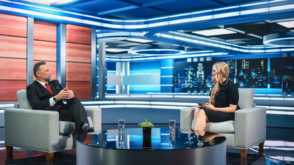 Talk Show TV Program Presenter and Celebrity Interview. Host and Guest Discuss Politics, Economy, Science, News, Entertainment. Mock-up of Cable Channel Studio. Wide Shot, Television Concept
