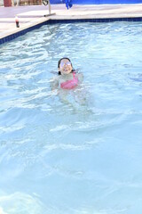 Young woman in pool with sunglasses