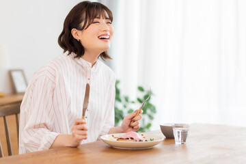 Obraz na płótnie Canvas 食事をする若い女性