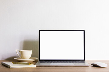 Mock up computer with books and coffee cup on table with natural light. 