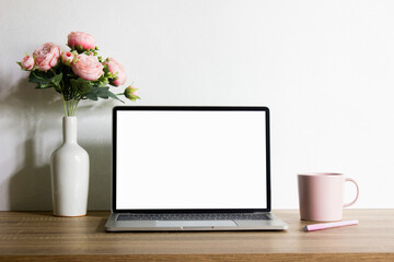 Mock up Computer with pink flower and pink coffee mug with nature light.
