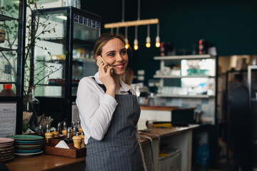 woman waitress talking with mobile phone in restaurant