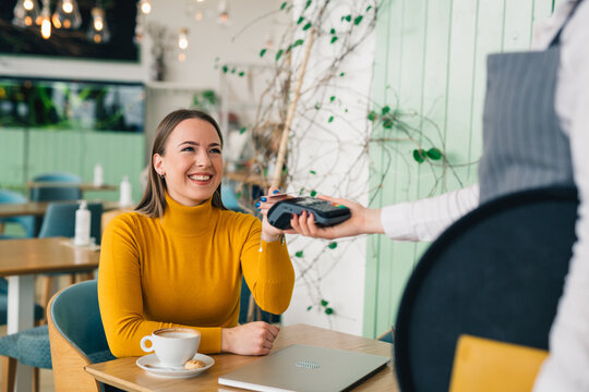 Woman Paying Bill Contactless With Credit Card In Restaurant