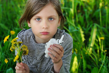 Portrait of little sad girl with allergy symptoms in nature