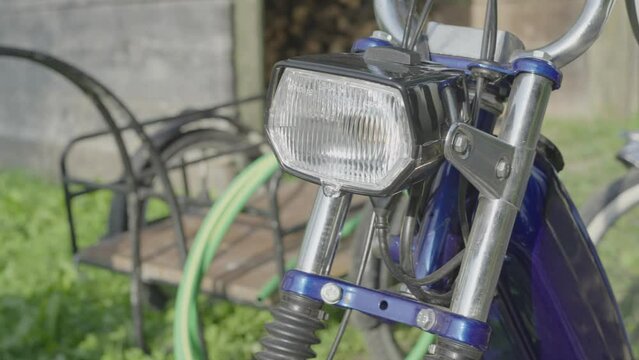 Close-Up of a vintage and tuned moped on a tour out in the green