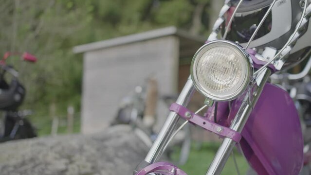 Close-Up of a vintage and tuned moped on a tour out in the green