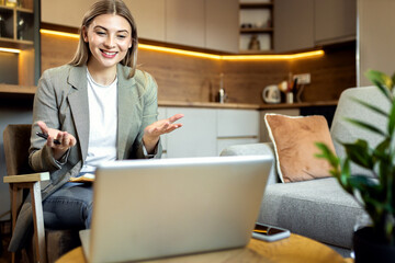 Young woman working from home using laptop for video call.