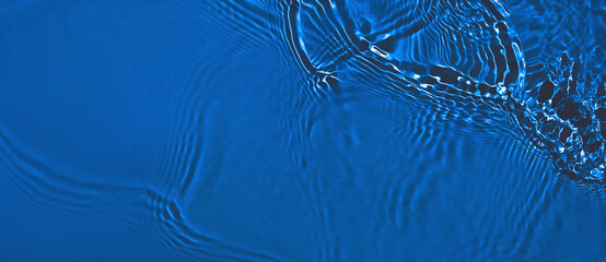 Transparent dark blue clear water surface texture with ripples and splashes. Abstract summer banner...