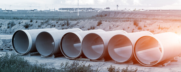 Stack of big frp composite fiberglass plastic sewage pipes at warehouse construction site near...
