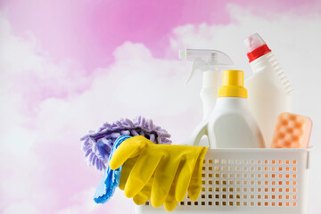  Cleaning products for cleaning, disinfection at home in a basket on the pink clouds.