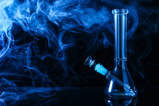 Glass bong and smoke on black background, space for text. Smoking device