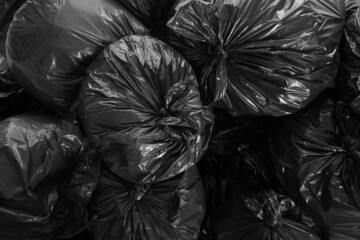 Fototapeta na wymiar Black trash bags full of garbage as background, top view