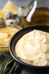 Delicious homemade mayonnaise with ingredients on grey table, closeup