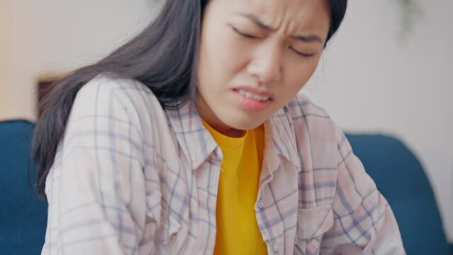 Young Asian woman feeling strong abdominal pain, gastrointestinal problems, pms