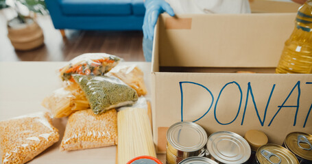 Donations food with oil, canned food, pasta, tomato paste on the wooden table. Donation, coronavirus and quarantine concept.