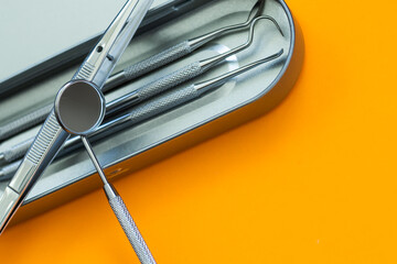 Dental mirror and other tools on orange background