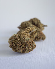 Cannabis buds dried, cured and trimmed against a light background